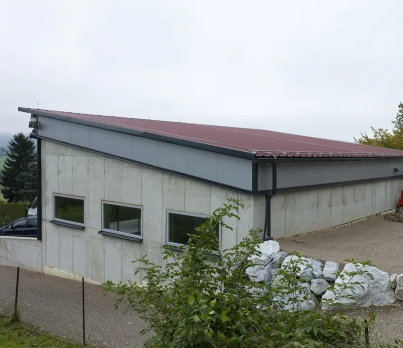 Halle mit rotem Pultdach und grauer Fassade